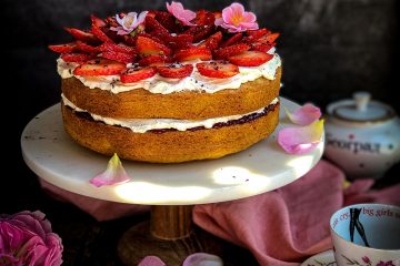 Victoria Sponge torta poslužena sa svežim jagodama i laticama ruže