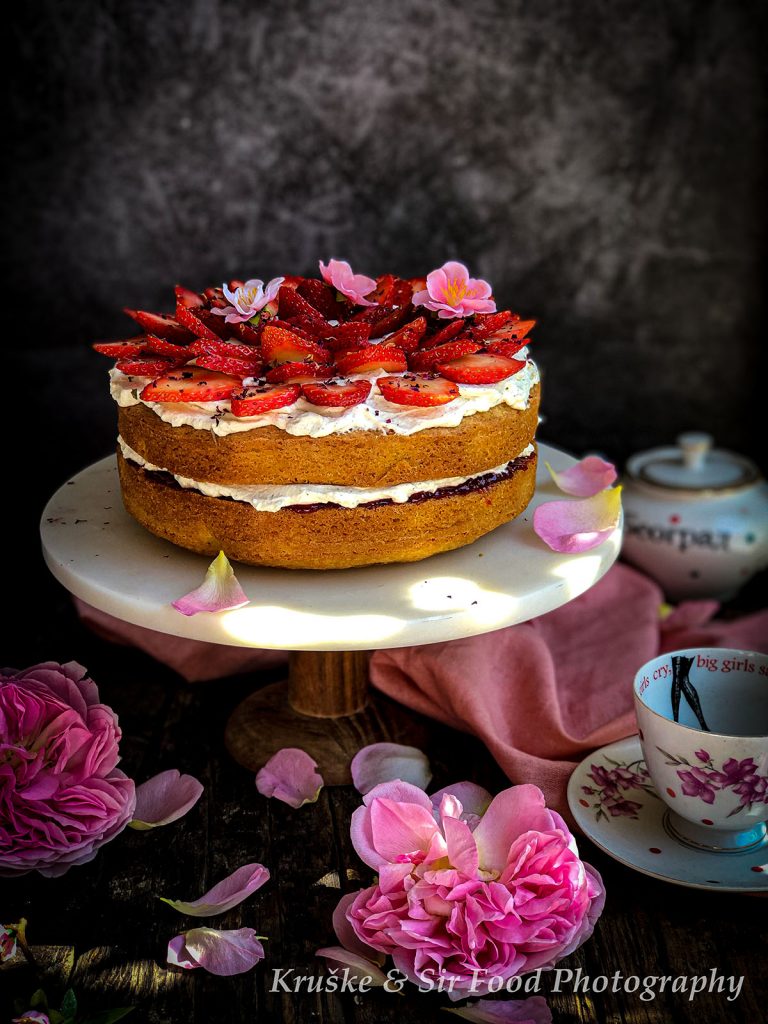 Victoria Sponge torta poslužena sa svežim jagodama i laticama ruže
